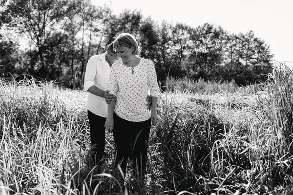 Pareja de mediana edad camina cerca del río — Foto de Stock