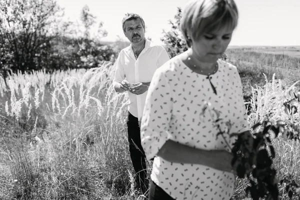 Casal de meia-idade caminha em grama alta — Fotografia de Stock