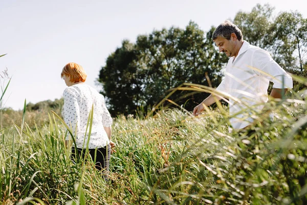 Orta yaşlı çift nehir kenarında yürüyor
