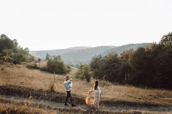 Junge Familie mit Tochter zu Fuß in den Bergen — Stockfoto