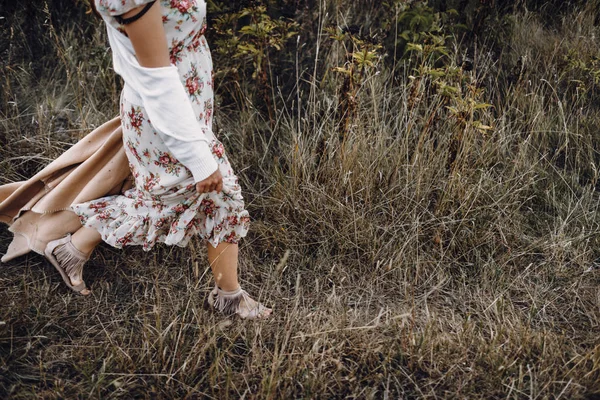 Девушка в цветочном платье на сухой траве — стоковое фото