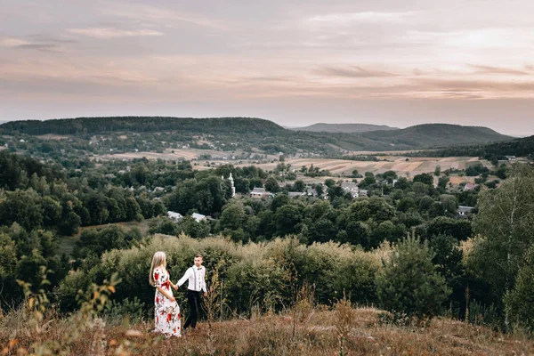 Älskande par på promenad i bergslandskap — Stockfoto
