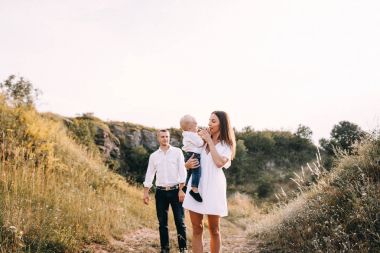 Genç aile çayırda yürüyüş