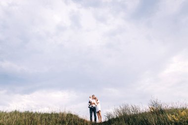 Genç aile çayırda yürüyüş