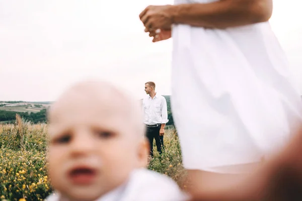 Ung familj promenader i äng — Stockfoto