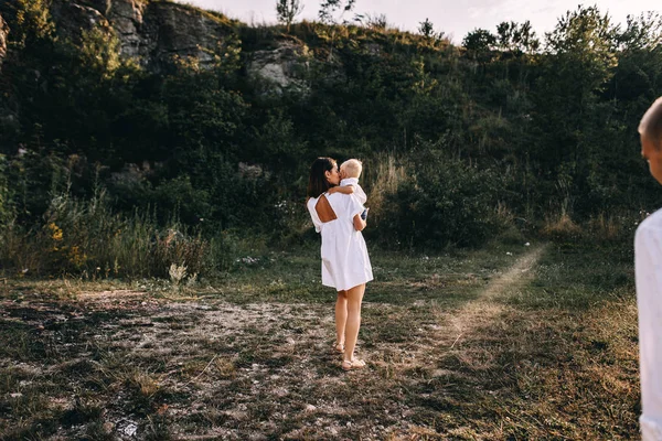 Ung familj promenader i äng — Stockfoto