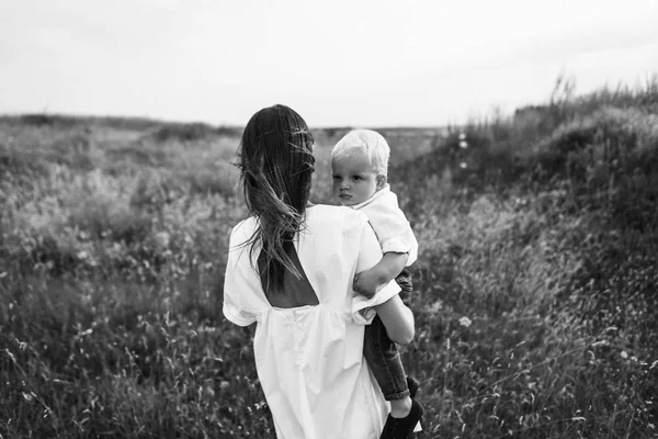 Joven hermosa madre con un hijo en el prado — Foto de Stock