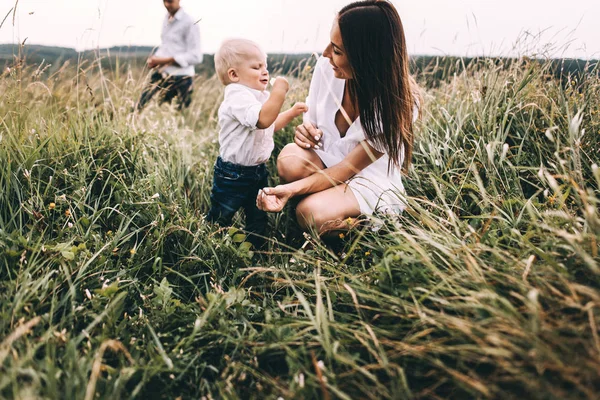 Young family walking in meadow — Stock Photo, Image
