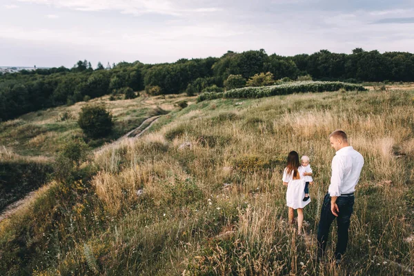 Ung familj promenader i äng — Stockfoto