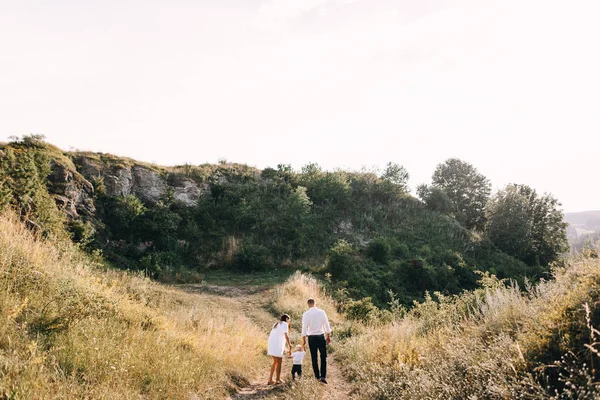 Junge Familie spaziert auf Wiese — Stockfoto