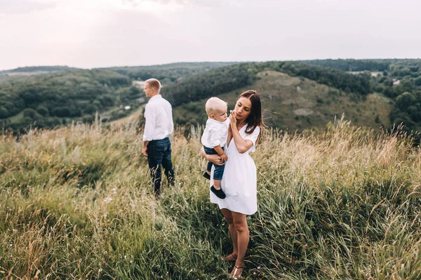 Genç aile çayırda yürüyüş
