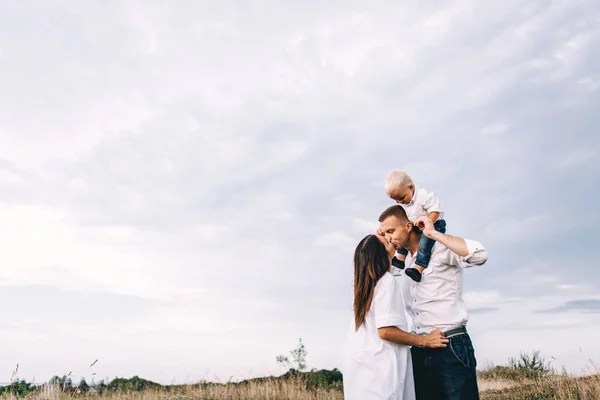 Ung familj promenader i äng — Stockfoto