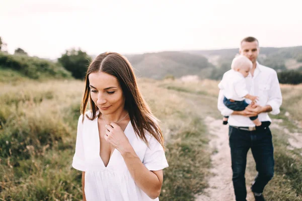 Ung familj promenader i äng — Stockfoto