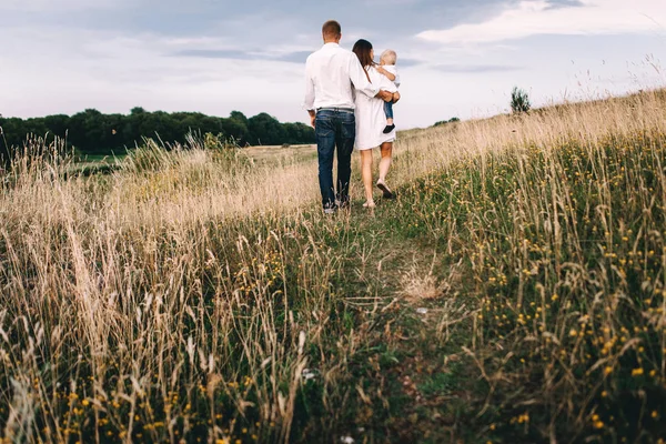 Young family walking in meadow — Stock Photo, Image