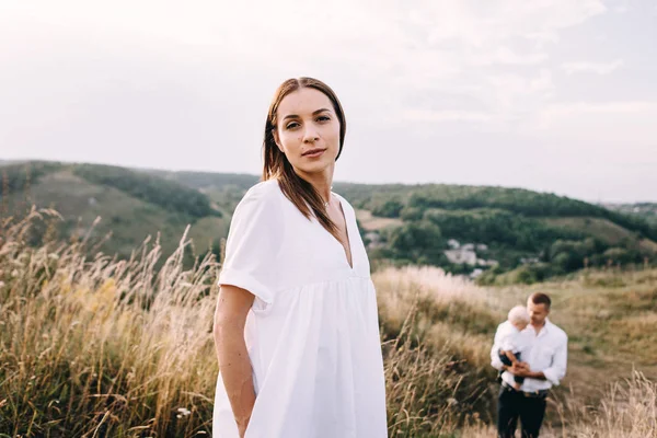 Junge Familie spaziert auf Wiese — Stockfoto