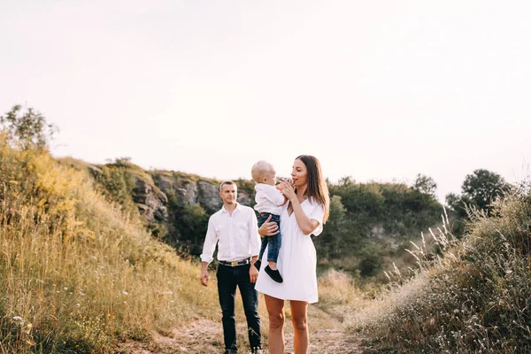 Молодая семья гуляет по лугу — стоковое фото