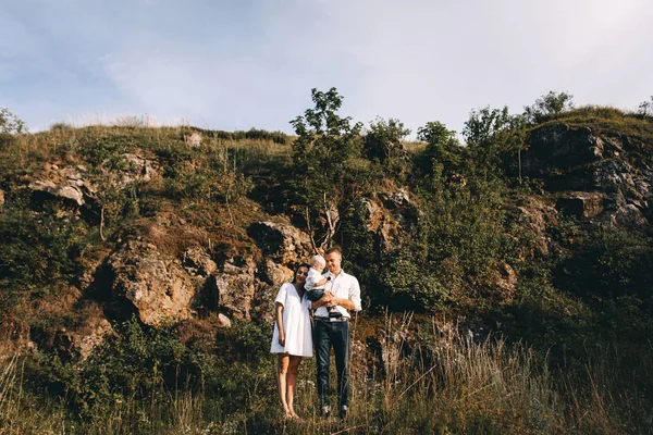 Ung familj promenader i äng — Stockfoto