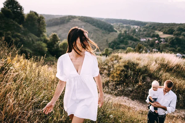 Familia joven caminando en el prado — Foto de Stock