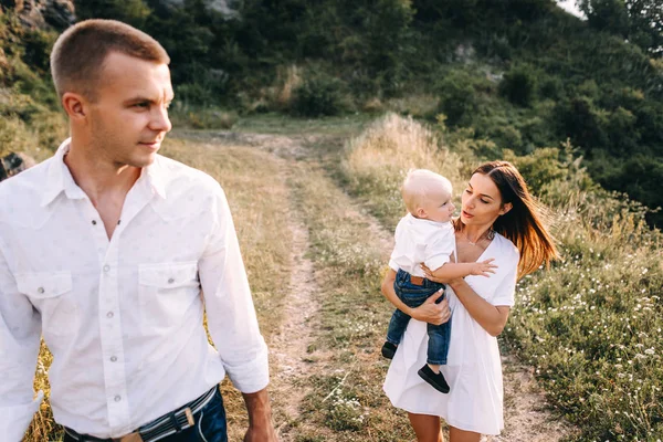 Familia joven caminando en el prado — Foto de Stock