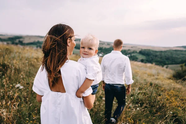 Ung familj promenader i äng — Stockfoto