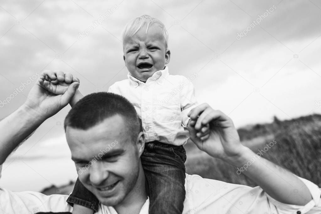 Young beautiful father with a son in meadow