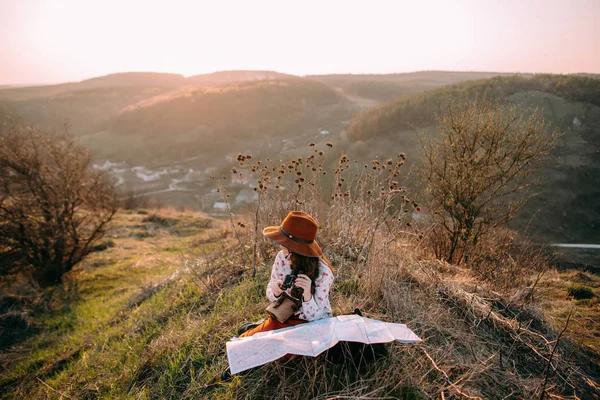 Traveler girl in mountains at sunset