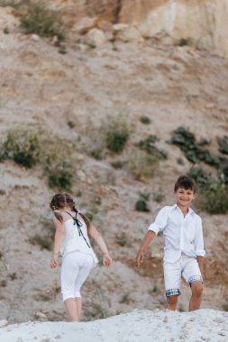 Çocuklar kumlu yerlerde bir yolda