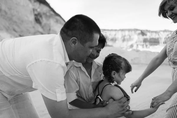 Lycklig familj promenader längs sandstranden förlägger — Stockfoto