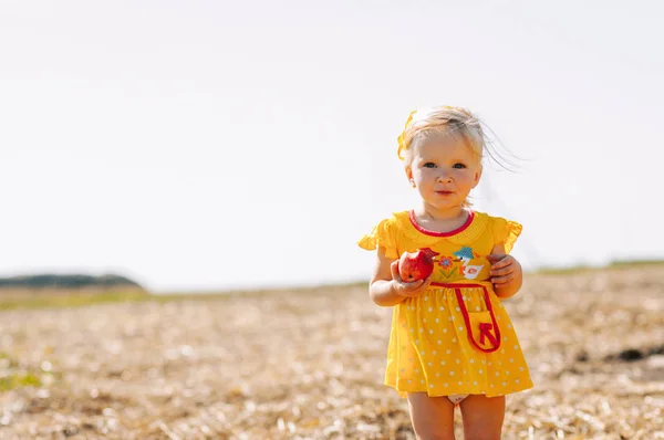 Menina com maçã no campo — Fotografia de Stock