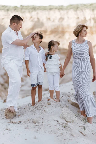 Lycklig familj promenader längs sandstranden förlägger — Stockfoto