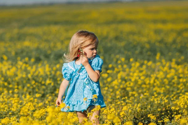 Menina no campo de flores amarelas — Fotografia de Stock