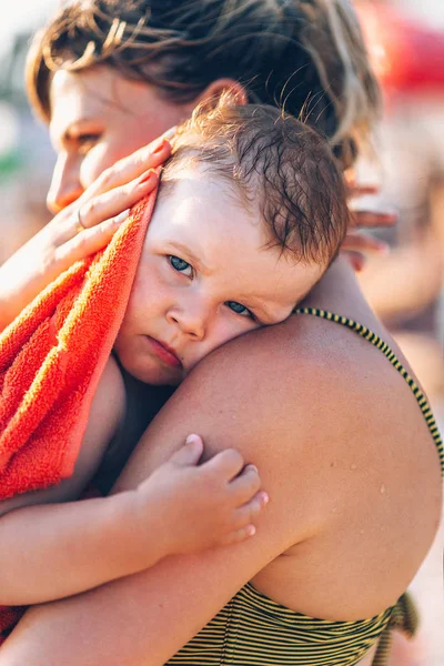 Bambino tra le braccia di sua madre in spiaggia — Foto Stock