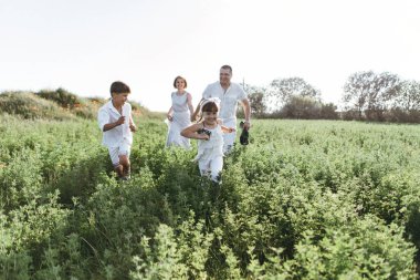 Anne, baba, kızı ve oğlu sahada