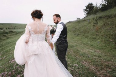 Yeni evliler, açık havada düğün gününde yürüyüş