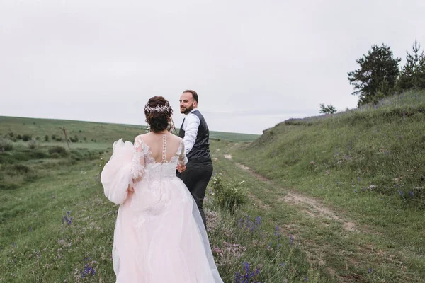 Nygifta promenad utomhus på deras bröllopsdag — Stockfoto