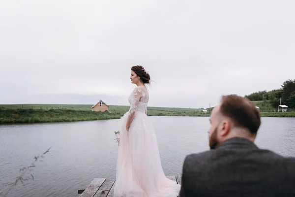 Recién casados caminan cerca del lago el día de su boda — Foto de Stock