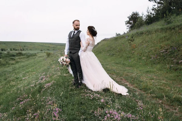 Nygifta promenad utomhus på deras bröllopsdag — Stockfoto