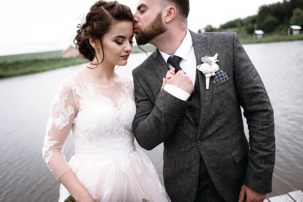 Recién casados caminan cerca del lago el día de su boda —  Fotos de Stock