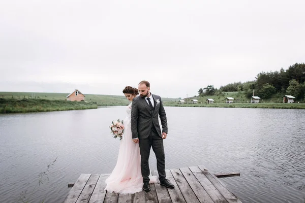 Frischvermählte gehen am Hochzeitstag am See spazieren — Stockfoto