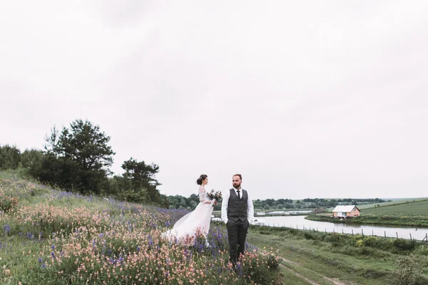 Nygifta promenad utomhus på deras bröllopsdag — Stockfoto