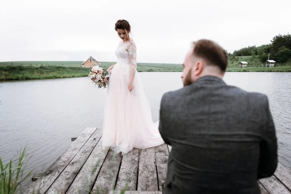 Newlyweds walk near lake on their wedding day — Stock Photo, Image