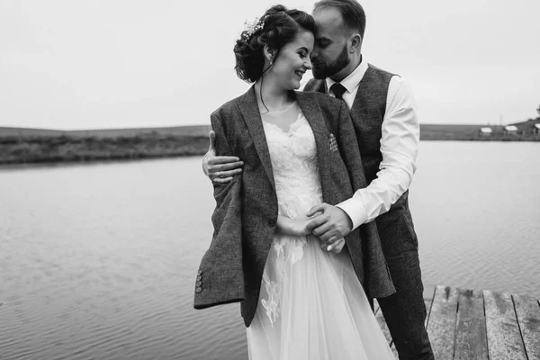 Frischvermählte gehen am Hochzeitstag am See spazieren — Stockfoto