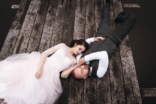 Os recém-casados caminham perto do lago no dia do casamento — Fotografia de Stock