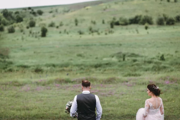 Recién casados caminan al aire libre el día de su boda — Foto de Stock
