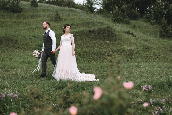 Nygifta promenad utomhus på deras bröllopsdag — Stockfoto