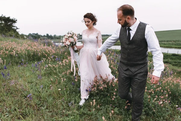 Nygifta promenad utomhus på deras bröllopsdag — Stockfoto