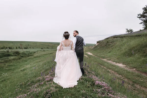 Nygifta promenad utomhus på deras bröllopsdag — Stockfoto