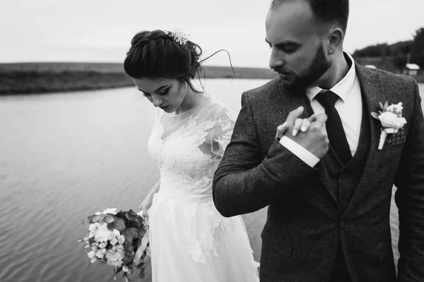 Молодожёны прогуливаются возле озера в день своей свадьбы — стоковое фото