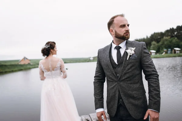 Recién casados caminan cerca del lago el día de su boda —  Fotos de Stock