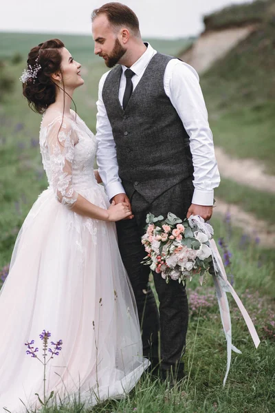 Recién casados caminan al aire libre el día de su boda — Foto de Stock